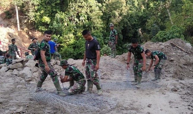 Operator Alat Berat Bersama prajurit dan warga Bersinergi Kerjakan Bronjong penahan longsor