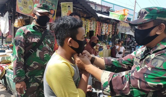 Terjun ke Lapangan, Babinsa Benowo Rela Pasangkan Masker ke Masyarakat